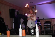 Žonglování s hořícími lahvemi při barmanské show