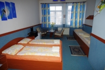 Čtyřlůžkový pokoj s jednou manželskou postelí a posezením