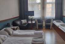 Čtyřlůžkový pokoj s jednou manželskou postelí a posezením